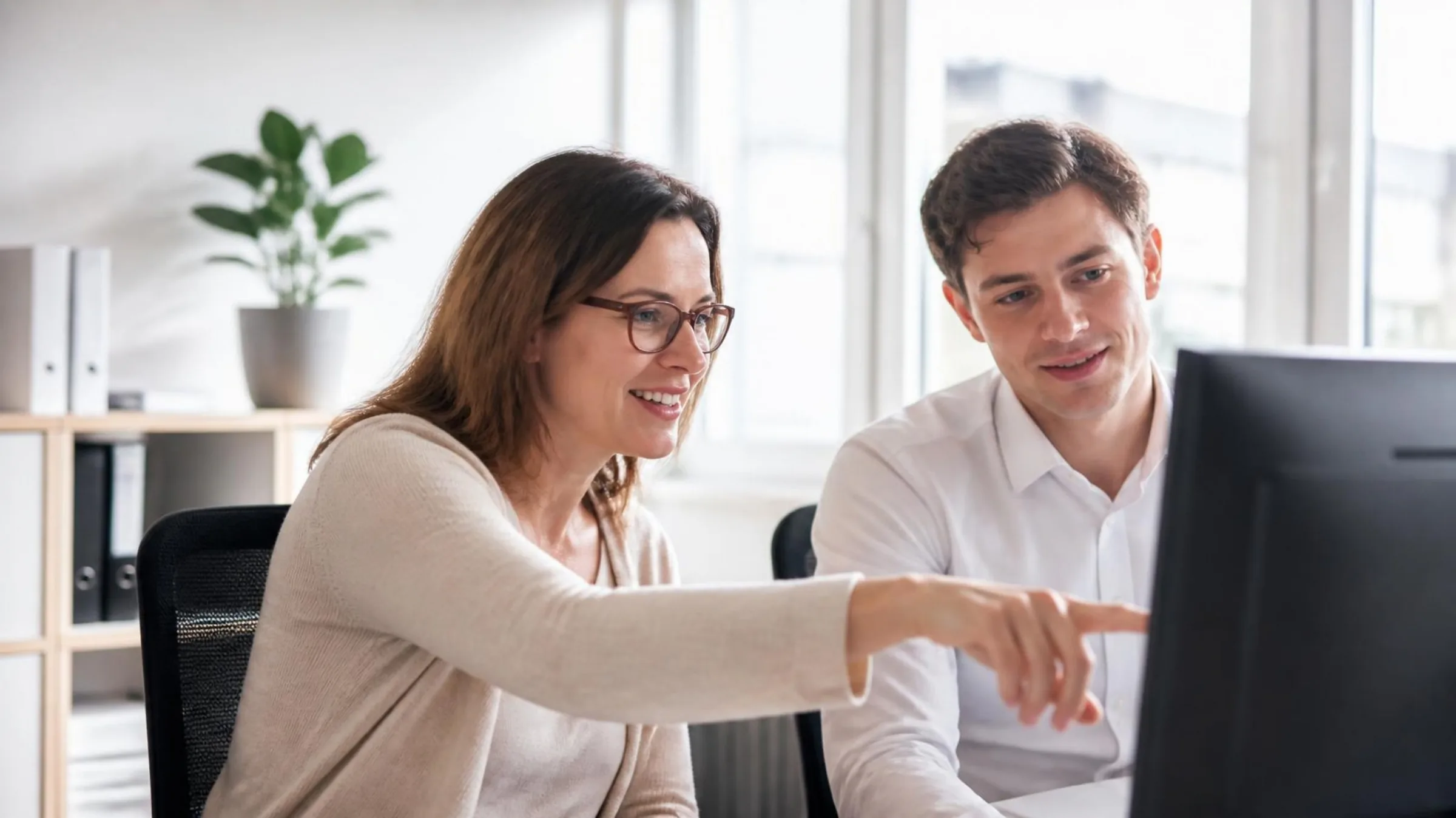 A knowledge manager and a colleague go through the firm’s model contracts on screen